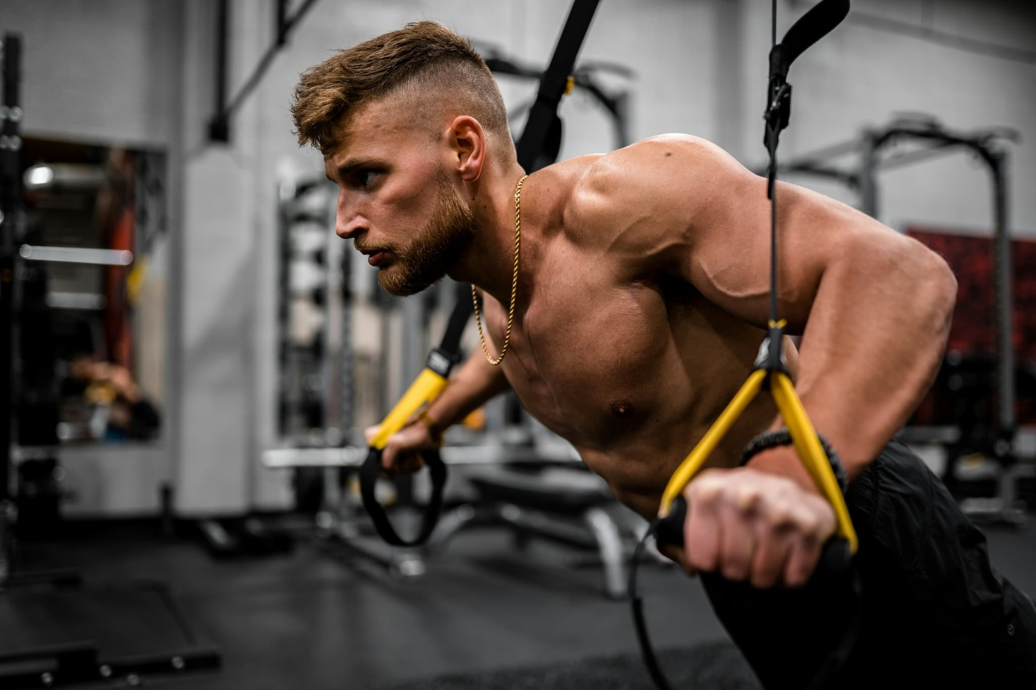 A person performing a compound lift such as a squat or deadlift in a clean gym environment
