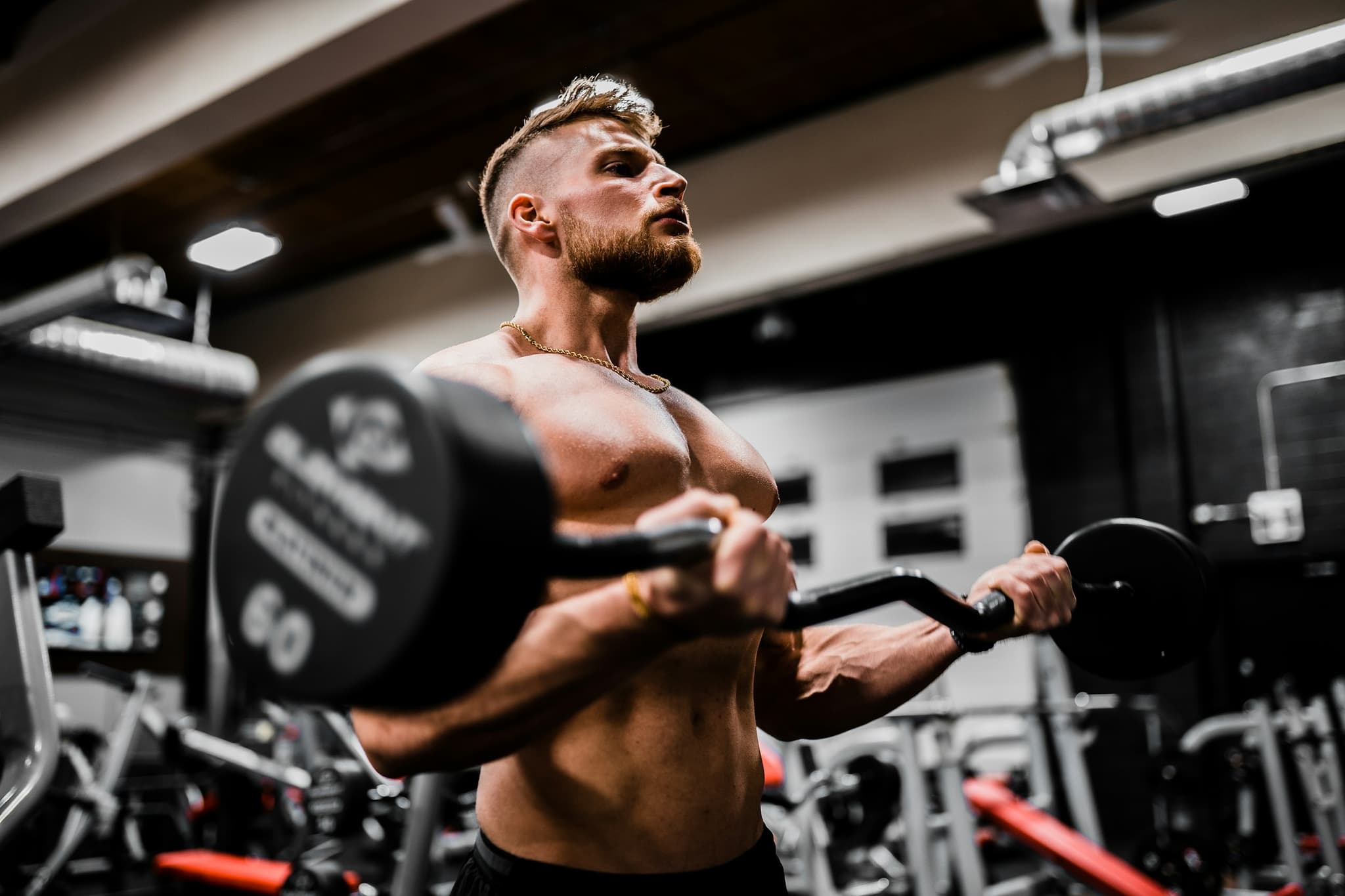 A coach guiding a client through an exercise in a clean, professional gym setting, conveying structure and expert guidance