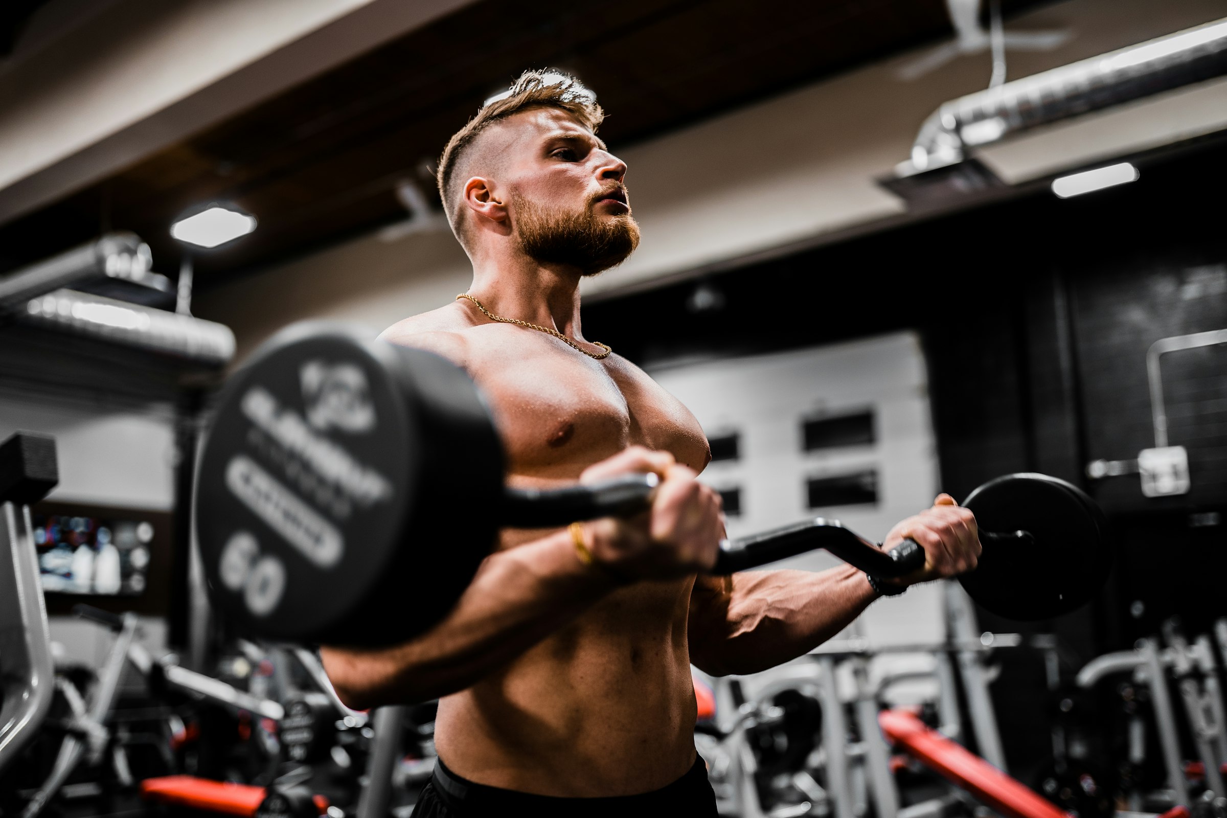 A coach guiding a client through an exercise in a clean, professional gym setting, conveying structure and expert guidance